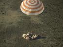 The Soyuz capsule carrying the three astronauts touches down in Kazakhstan. [NASA photo by Bill Ingalls]